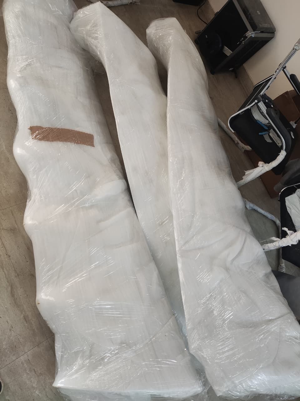Three blade moulds still in shrink wrap, lying side by side on the workshop floor.