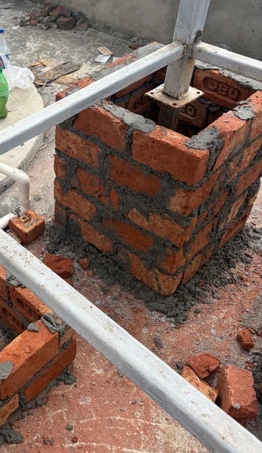 Brick pedestals and a scaffold frame being built on the rooftop for the stand.
