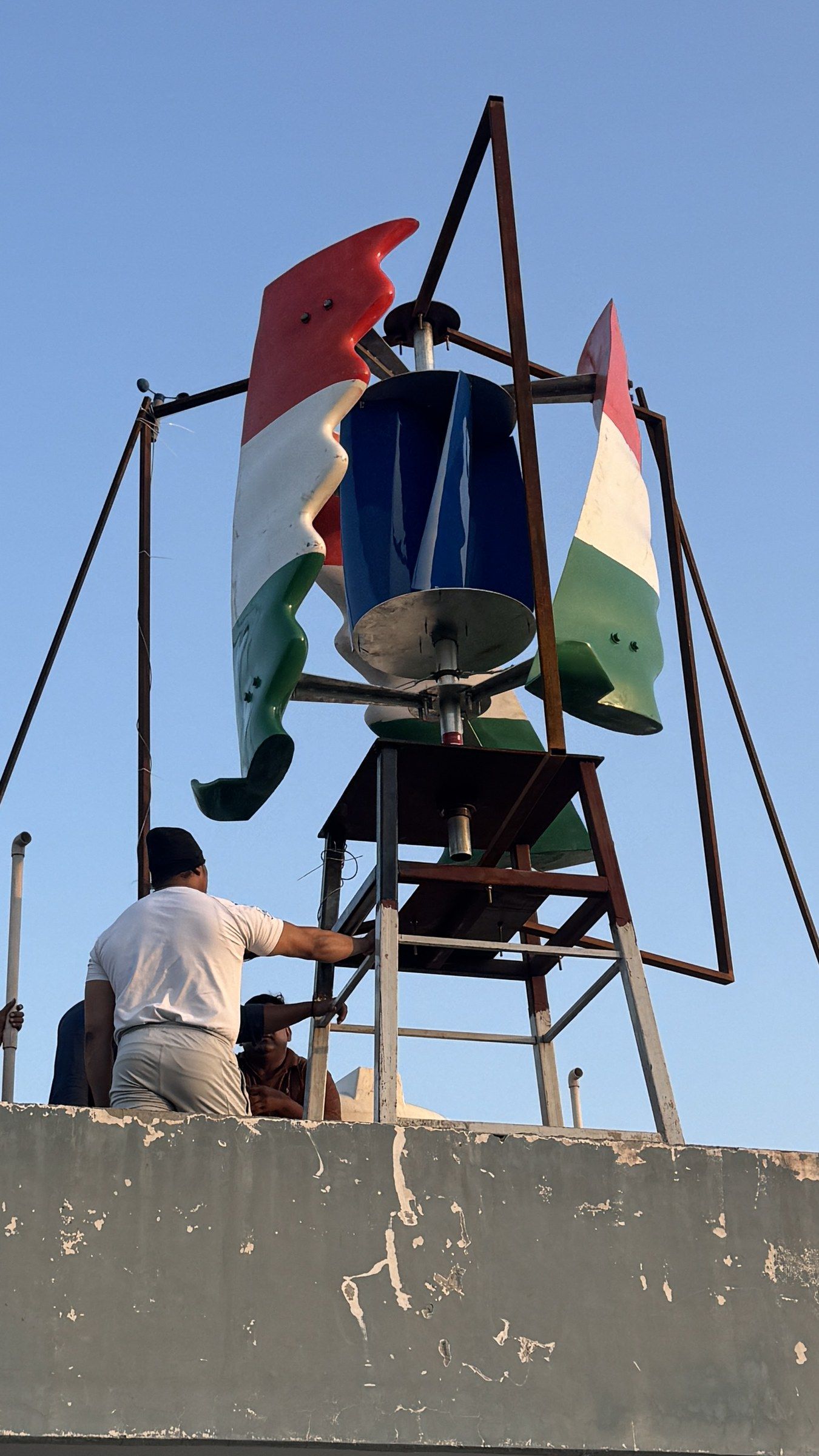 The full-size GIVARA ONE in tricolour on its rooftop stand, with the crew at the parapet, September 2026.
